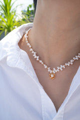 Close-up of model's neckline adorned with the Madeline Camellia Pearl Necklace