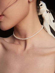 Close-up of model wearing Harper Pearl Necklace and Bracelet set