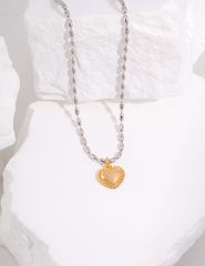 Close-up view of Olivia Sterling Silver Heart Necklace with vintage gold pendant and platinum beads